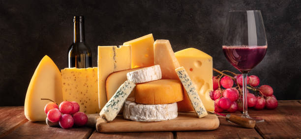 istock Cheese and wine panorama on a black background. Many different cheeses 1310862688
