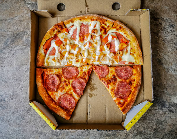 istock Pieces of two different pizza slices in a cardboard pizza box 1310862926