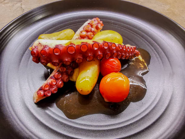 istock Octopus tentacles with garnish served on a black plate 1310862929