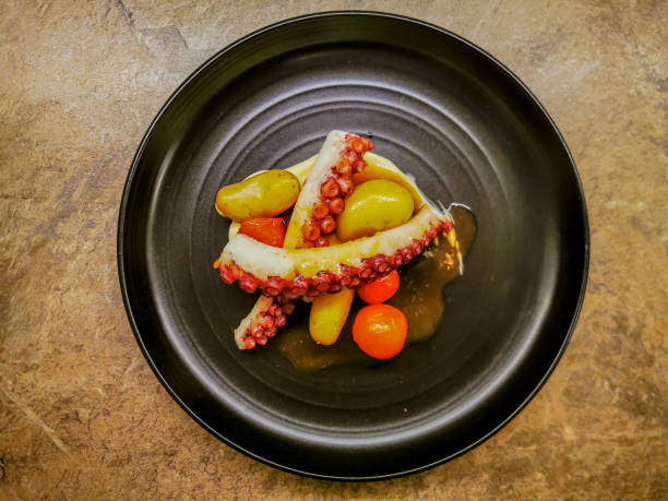 istock Octopus tentacles with garnish served on a black plate 1310862930
