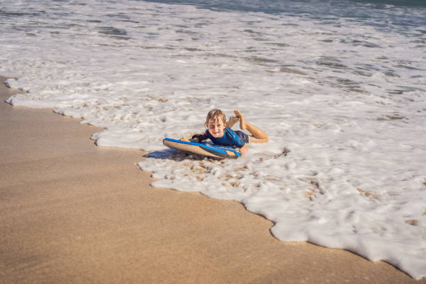 istock Happy Young boy having fun at the beach on vacation, with Boogie board 1310863167
