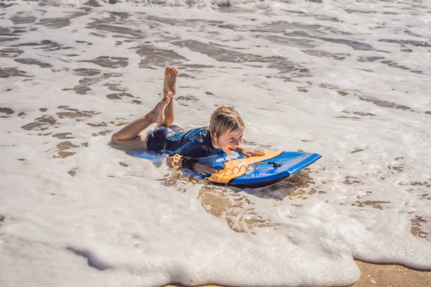 istock Happy Young boy having fun at the beach on vacation, with Boogie board 1310863170