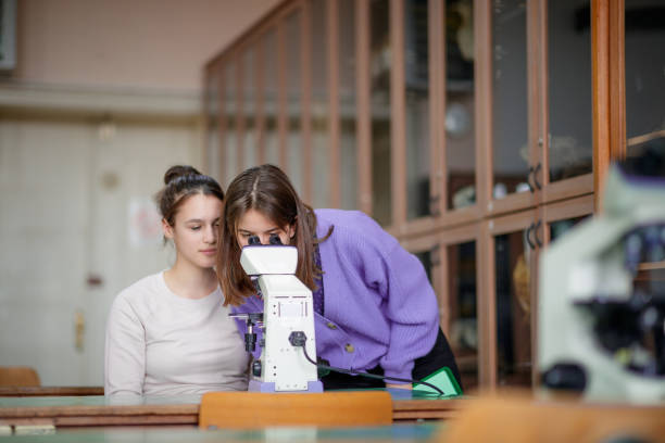 istock High school girl letting her classmate look through microscope oculars in biology class 1310864468