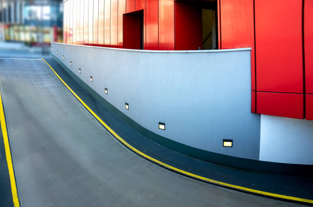 Entrance to an underground car park with modern red and grey wall cladding