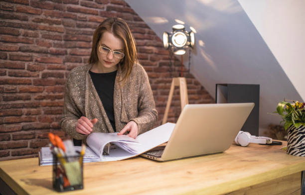 istock Businesswoman doing paperwork and using a laptop in the office 1310865745