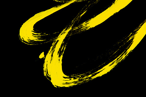 Neon yellow acrylic paint stroke isolated over black