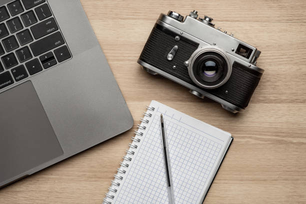 istock Top view off office photography desk table with laptop, notebook, camera and pen. 1310866933