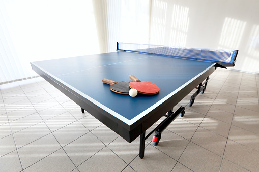 Blue table tennis table in room.
