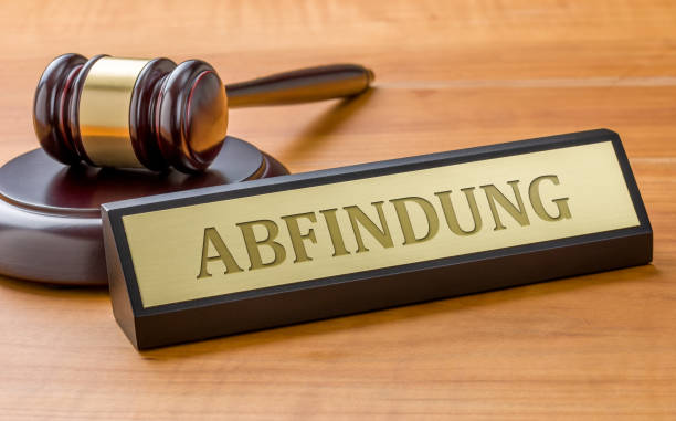 istock A gavel and a name plate with the engraving Compensation in german - Abfindung 1310873953