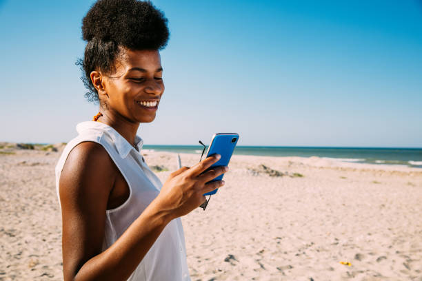 istock Woman texting by the beach 1310876774