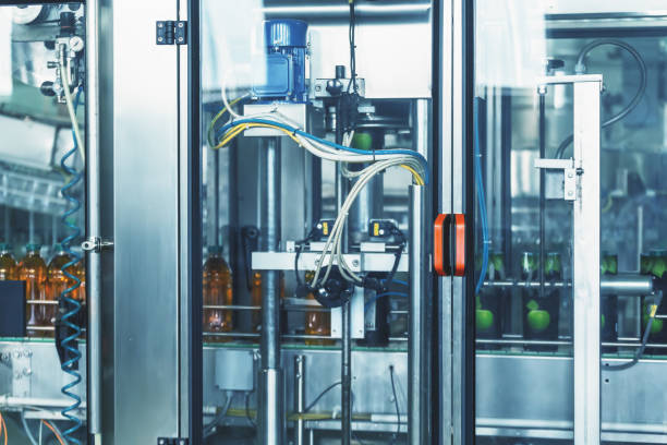 istock Automatic machine for dressing packaging for plastic bottles with drink in factory, industrial production of juices and other drinks 1310876902