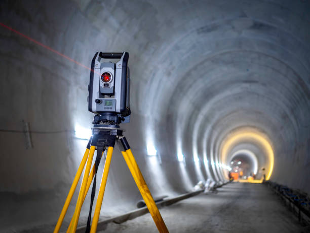 Theodolite at underground railway tunnel construction work. Theodolite at underground railway tunnel construction work. Construction survey equipment instrument on concrete circular tunnel background. theodolite photos stock pictures, royalty-free photos & images