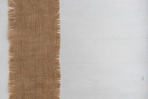 istock Rough linen napkin on a white wooden background with space for text. Layout. 1310880305