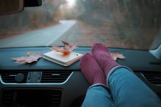 istock Woman feet in warm socks on car dashboard. 1310880414