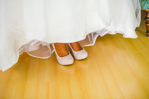 High heels wedding shoes decorated with pearls on a bride
