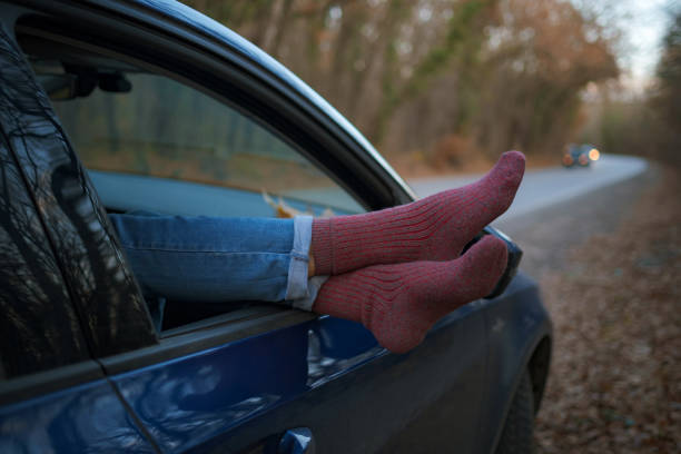 istock Woman feet in warm socks on car dashboard. 1310880649