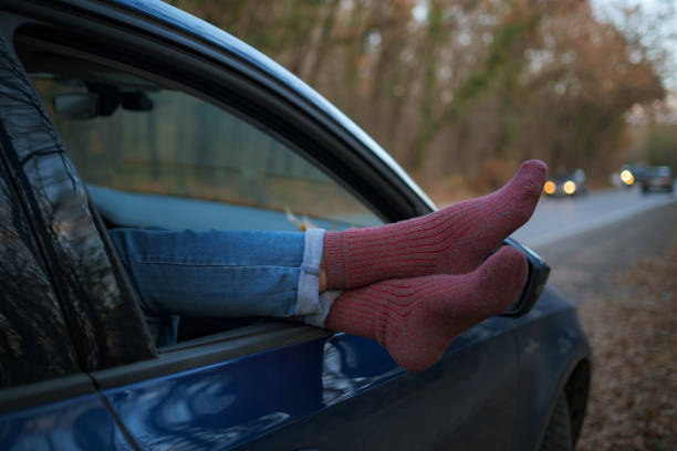 istock Woman feet in warm socks on car dashboard. 1310881944