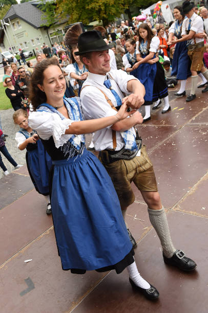 Traditional folk dance in Austria A dancing pair in traditional clothing at a public performance of a traditional Austrian folk dance at the farmers' market in Mondsee, Austria dirndl traditional clothing austria traditional culture stock pictures, royalty-free photos & images