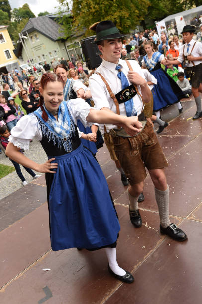 Traditional folk dance in Austria A dancing pair in traditional clothing at a public performance of a traditional Austrian folk dance at the farmers' market in Mondsee, Austria dirndl traditional clothing austria traditional culture stock pictures, royalty-free photos & images