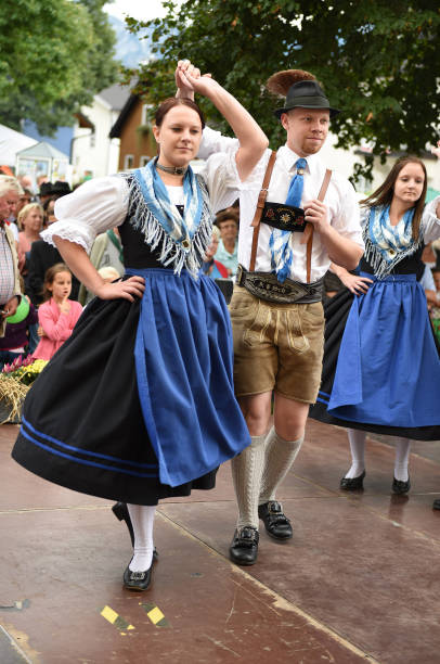 Traditional folk dance in Austria A dancing pair in traditional clothing at a public performance of a traditional Austrian folk dance at the farmers' market in Mondsee, Austria dirndl traditional clothing austria traditional culture stock pictures, royalty-free photos & images