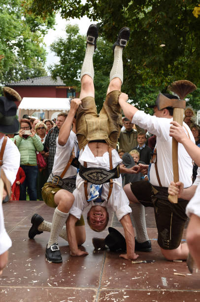 Traditional folk dance in Austria A folk dancer upside down at a public performance of a traditional Austrian folk dance at the farmers' market in Mondsee, Austria dirndl traditional clothing austria traditional culture stock pictures, royalty-free photos & images