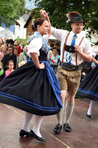 Traditional Austrian folk dance A pair in traditional clothing at a public performance of a traditional Austrian folk dance at the farmers' market in Mondsee, Austria dirndl traditional clothing austria traditional culture stock pictures, royalty-free photos & images