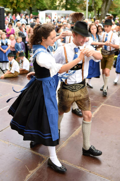 Traditional folk dance in Austria A dancing pair in traditional clothing at a public performance of a traditional Austrian folk dance at the farmers' market in Mondsee, Austria dirndl traditional clothing austria traditional culture stock pictures, royalty-free photos & images