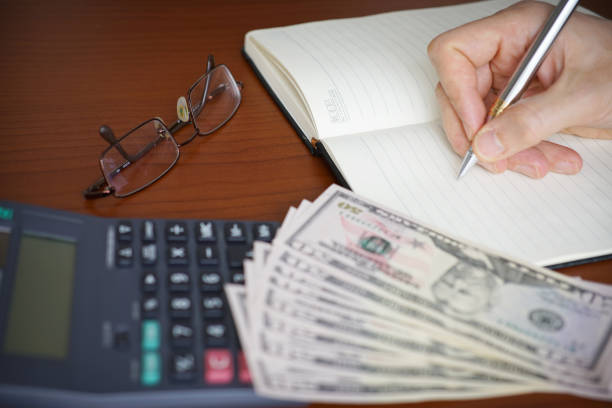 Business Man Using Pen And Calculator On Desk