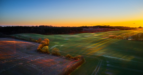 Springtime landscape. Agricultural area. Living fences and mixed meadows and cultivated land. Aerial view at sunset