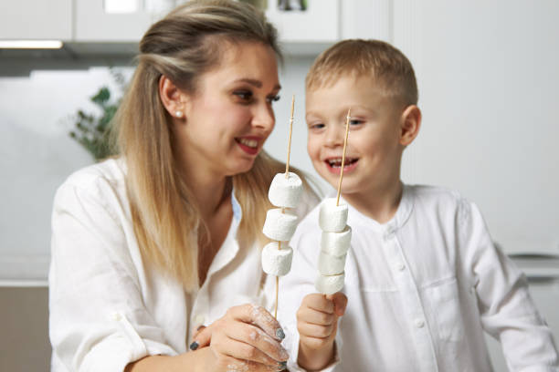 istock Happy mom and son put on marshmallows on a stick 1310886032