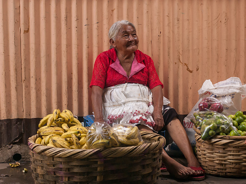 Managua, Nicaragua. 03-23-2019. Old smiling woman selling vegetables at a local market in the city of Managua.