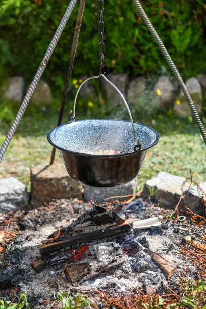 Photo of Hungarian pot over the fire bogracs during cooking the dish.