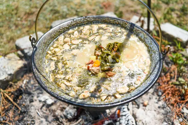 Photo of Hungarian pot over the fire bogracs during cooking the dish.