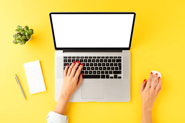 istock Female hands working on laptop with copyspace on yellow background with business accessories. Top view 1310892887
