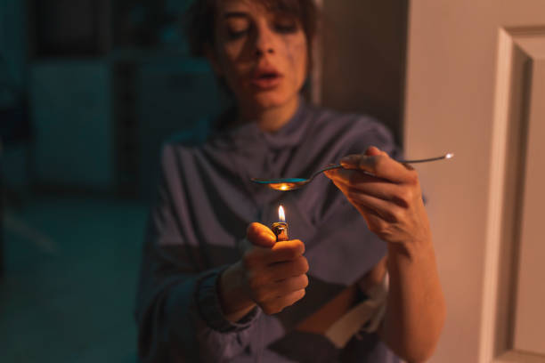 istock Junkie using lighter and spoon in preparation of intravenous cocaine dose 1310895572