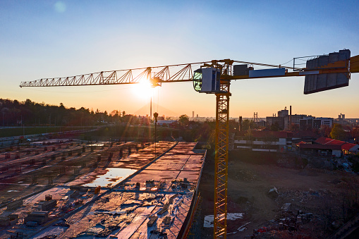 Building with cranes with lens flare in the background.Drone photo. Areal shoot of the city construction site