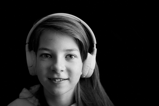 a teenage girl listens to music with headphones