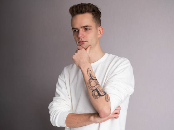 Handsome young guy with snake tattoo on his arm