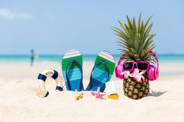 l’été à la fête.  hipster pineapple fashion en lunettes de soleil et écouter de la musique avec écran solaire et sandale sur la plage de sable beau fond ciel bleu.  fruit créatif d’art pour le modèle tropical. - moisturizing cream audio photos et images de collection