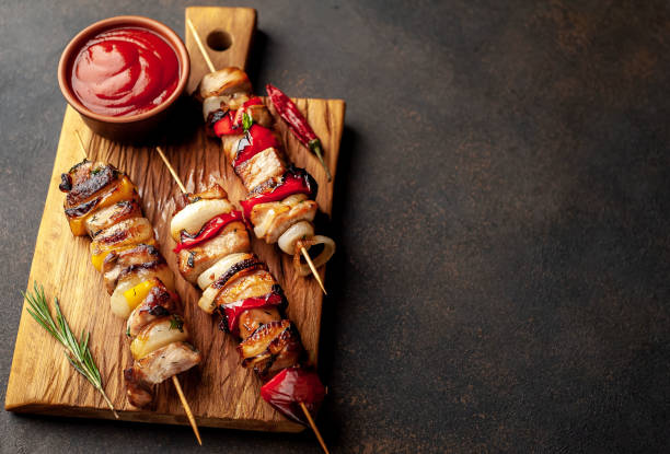 istock Meat skewers with grilled vegetables on a stone background  with copy space for your text 1310899354