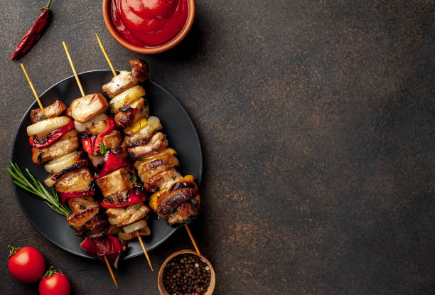 istock Meat skewers with grilled vegetables on a stone background  with copy space for your text 1310899377