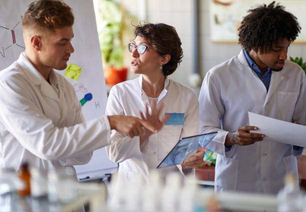 istock Team of young laboratory technicians discussing test results 1310901628