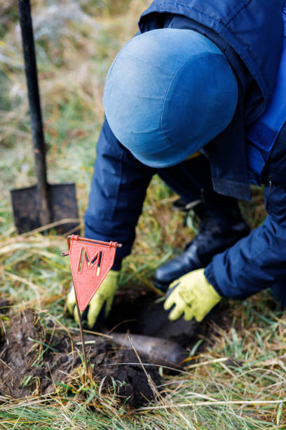 istock A man in a special suit works with a detector and found an explosive device. Dangerous work 1310902335