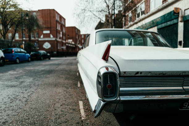 London, UK - 1 April, 2021: an old vintage white Cadillac car parked on a residential city street in London, UK.