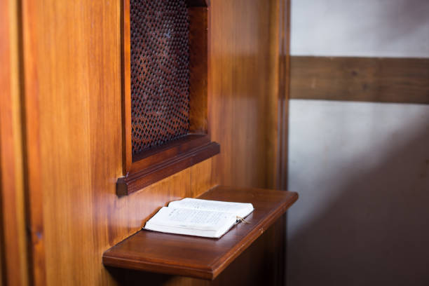 vieux prêtre à l’intérieur du confessionnal en bois dans une église chrétienne. - confession booth church forgiveness wood photos et images de collection