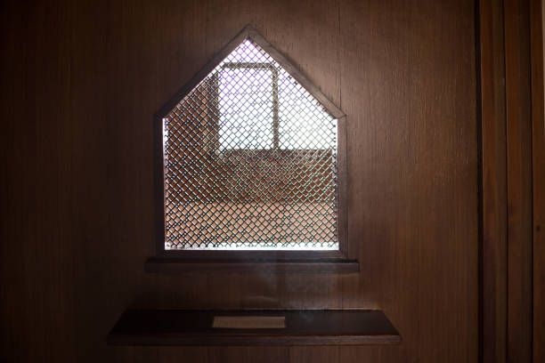 viejo sacerdote dentro del confesionario de madera en una iglesia cristiana. - confession booth penance catholicism church fotografías e imágenes de stock