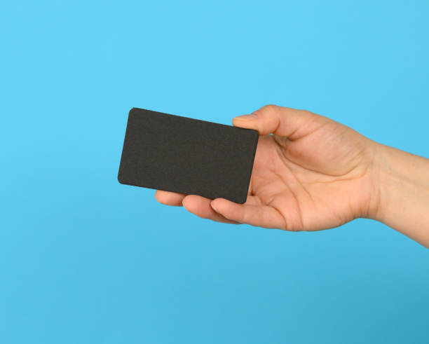 istock female hand holding a stack of blank black business cards 1310904955