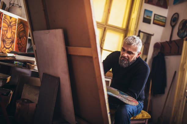 istock Mature man painting on canvas in art studio. 1310905057