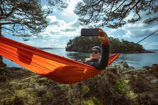 ノルウェーの春:ハンモックの屋外自然の中で自分撮り - summer women hammock nature ストックフォトと画像