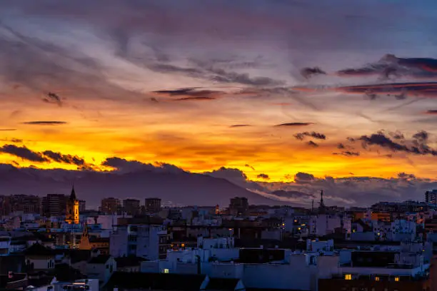 Photo of Blue hour view over Malaga, Spain in Sunset Colors - partly cloudy with yellow and red sky